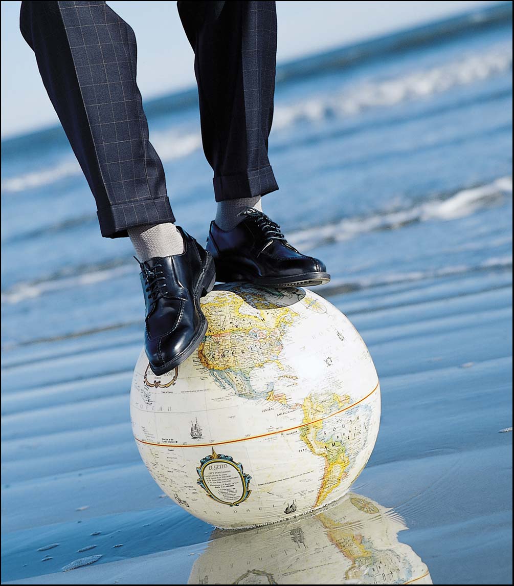 man standing on a globe wearing socks in the ocean